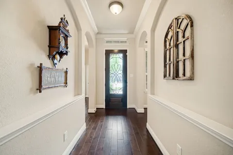 a view of a hallway with wooden floor and staircase