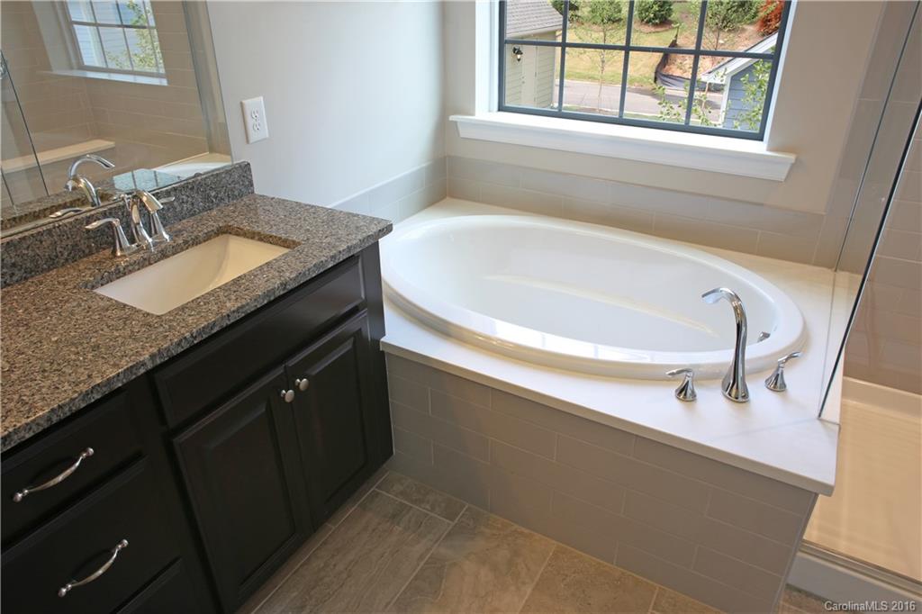 140 Helton Lane, Unit 36 Fort Mill, SC 29708 - Photo 13 of 21 a bathroom with a granite countertop sink and a bathtub