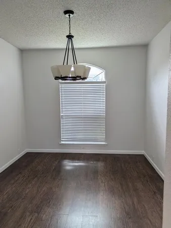 a view of a small space with wooden floor and a window