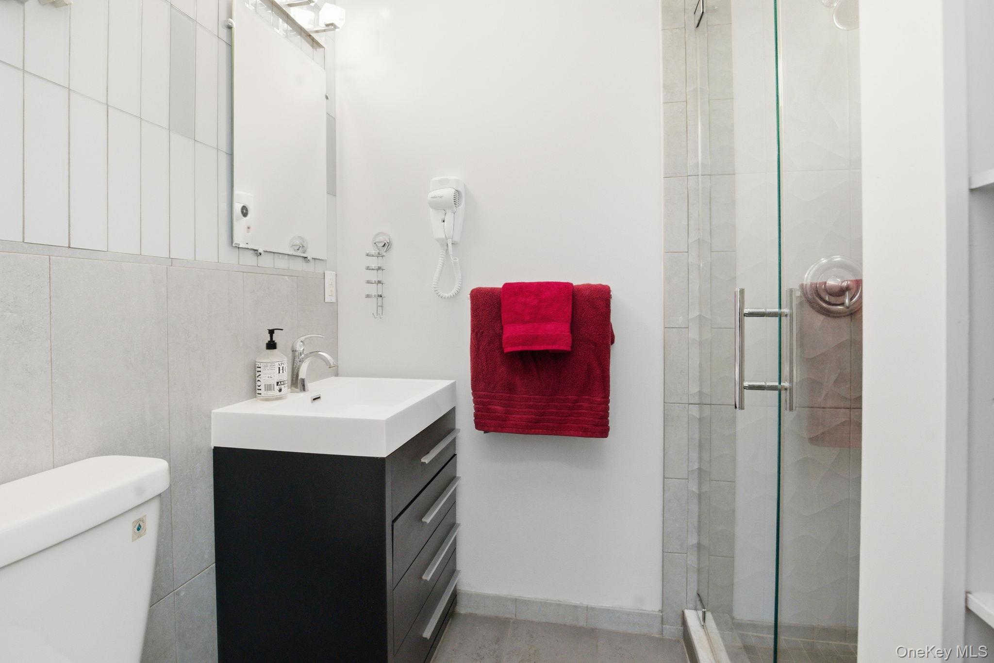 35 Deans Bridge Road Somers, NY 10589 - Photo 20 of 49 The private en suite bath is freshly updated with a glass shower, sleek vanity, and crisp tilework.