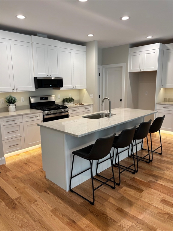 190 Whitins Road Sutton, MA 01590 - Photo 12 of 15 a kitchen with stainless steel appliances kitchen island granite countertop a stove a sink a microwave a dining table and chairs