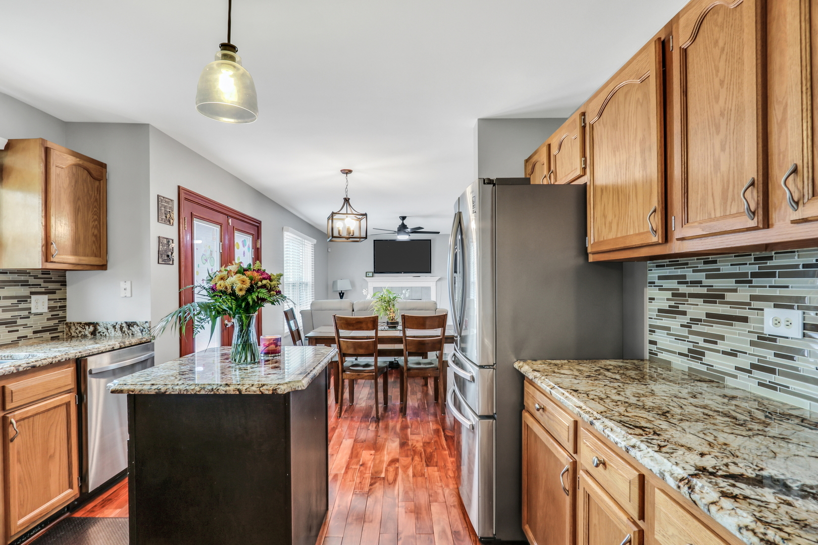 4049 Ridge Road Zion, IL 60099 - Photo 5 of 28 a kitchen with granite countertop a stove a sink dishwasher and a refrigerator with wooden floor