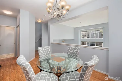 a view of a dining room with furniture a chandelier and wooden floor