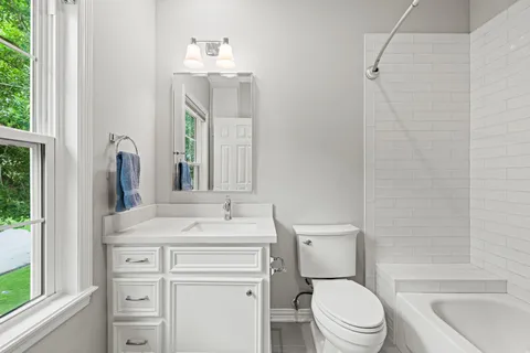 a bathroom with a sink toilet vanity and tub