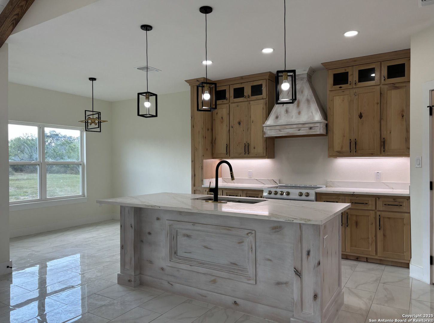 809 North Camp Street Uvalde, TX 78801 - Photo 11 of 30 a kitchen with a sink stainless steel appliances granite countertop cabinets and a window