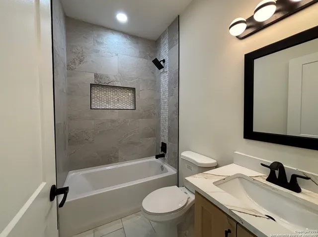 a bathroom with a granite countertop sink toilet a mirror and shower