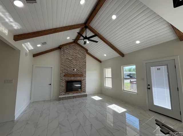 a view of an empty room with a fireplace and a window