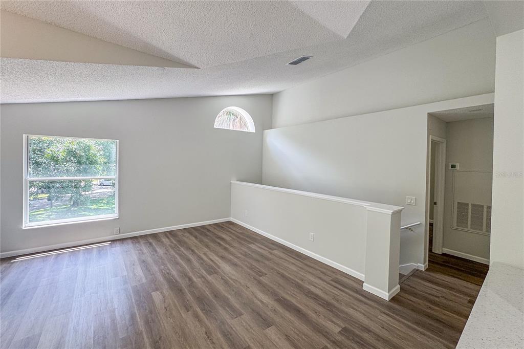 5436 East Michigan Street, Unit 4 Orlando, FL 32812 - Photo 11 of 37 an empty room with wooden floor and windows