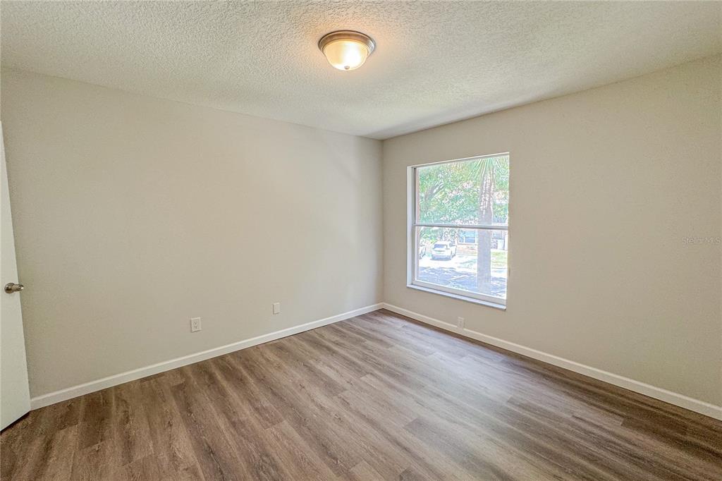 5436 East Michigan Street, Unit 4 Orlando, FL 32812 - Photo 20 of 37 an empty room with wooden floor and windows