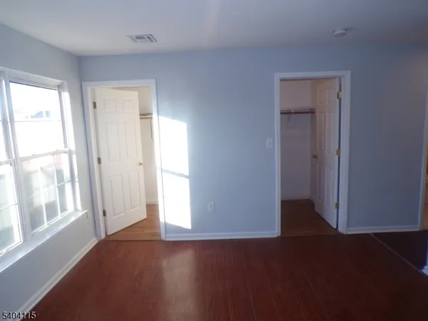 a view of a livingroom with wooden floor and a window