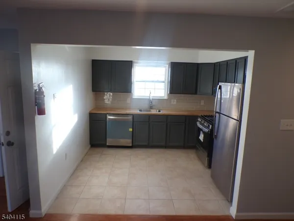 a kitchen with stainless steel appliances granite countertop a refrigerator a sink and a stove