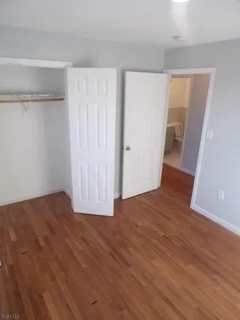 an empty room with wooden floor and closet