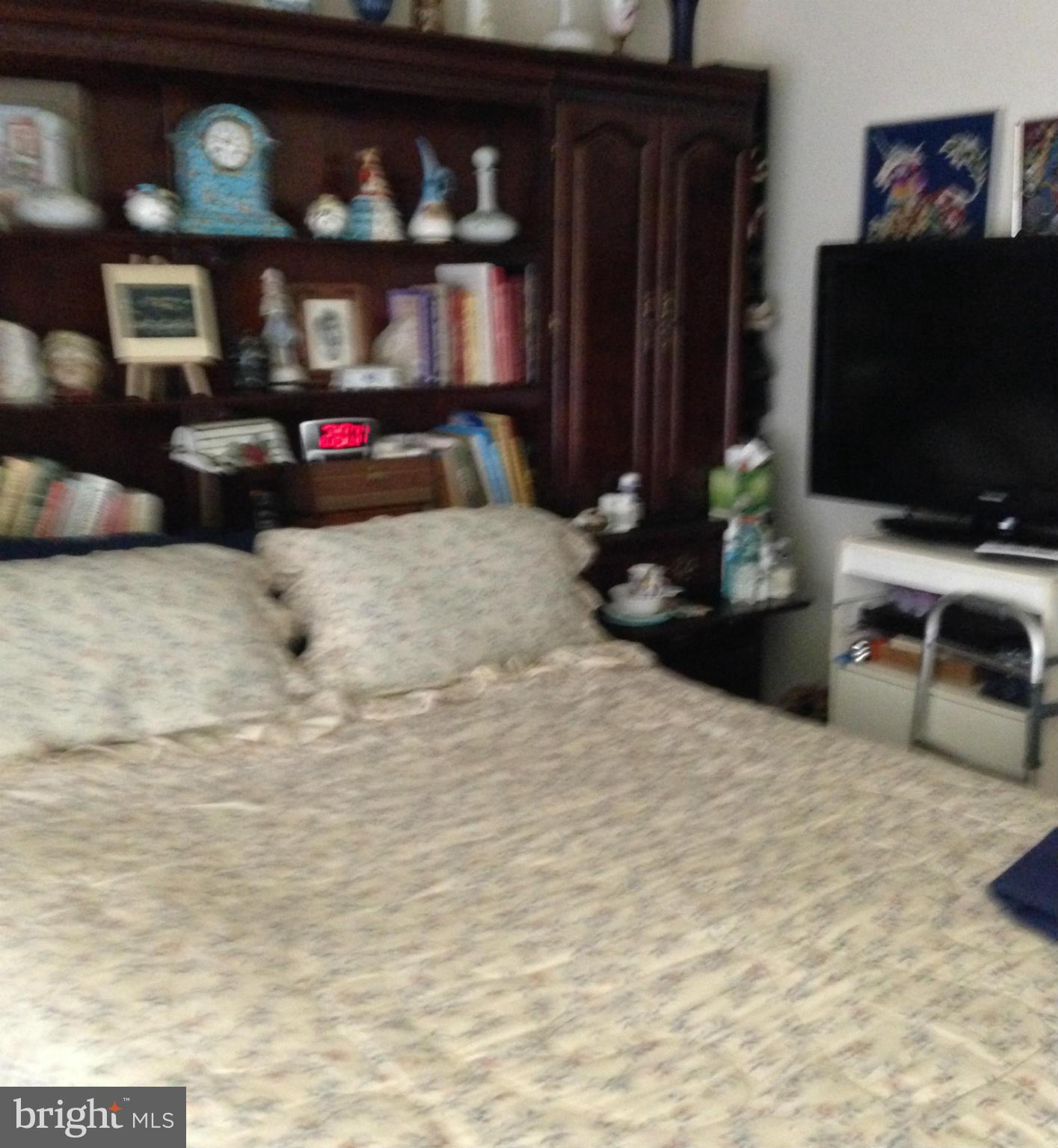 3011 Fallstaff Road, Unit 107A Baltimore, MD 21209 - Photo 7 of 14 a bedroom with furniture and a flat tv screen