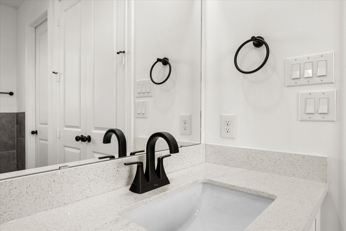311 Tennessee Street Houston, TX 77029 - Photo 20 of 38 a bathroom with a granite countertop sink a toilet and mirror