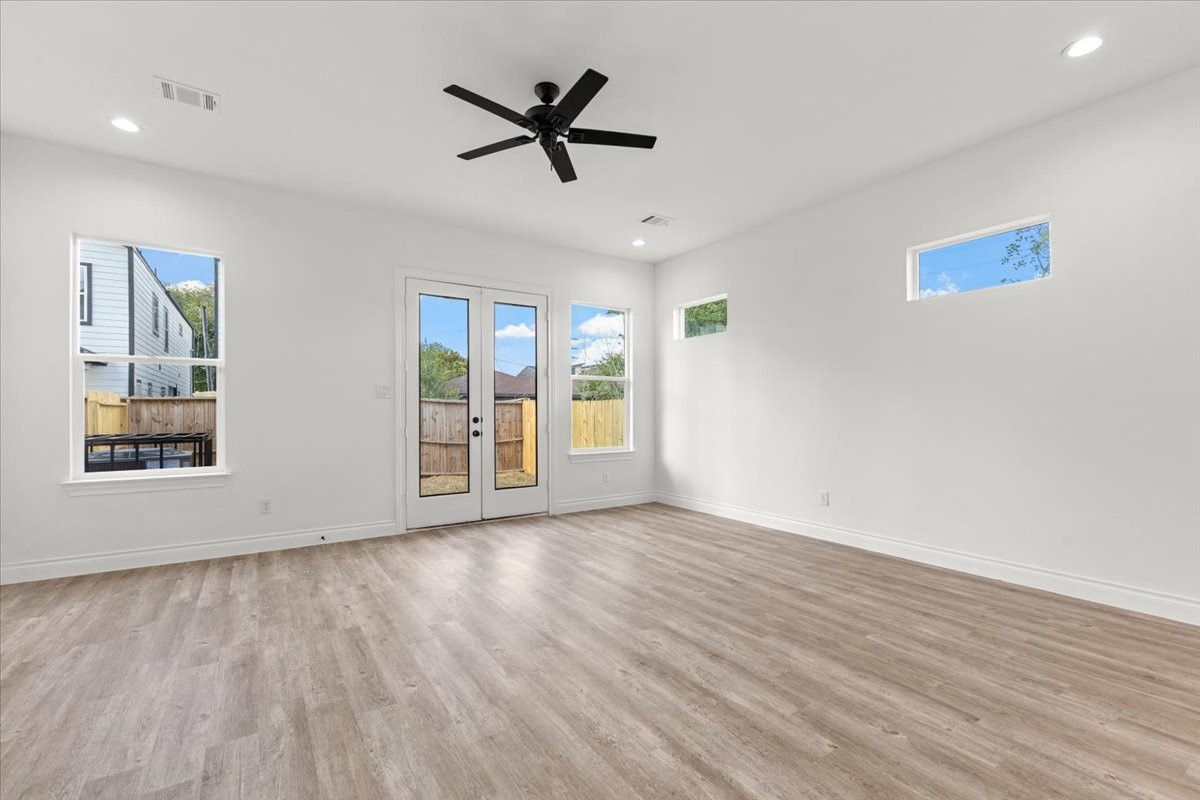 311 Tennessee Street Houston, TX 77029 - Photo 5 of 38 a view of an empty room with window and wooden floor