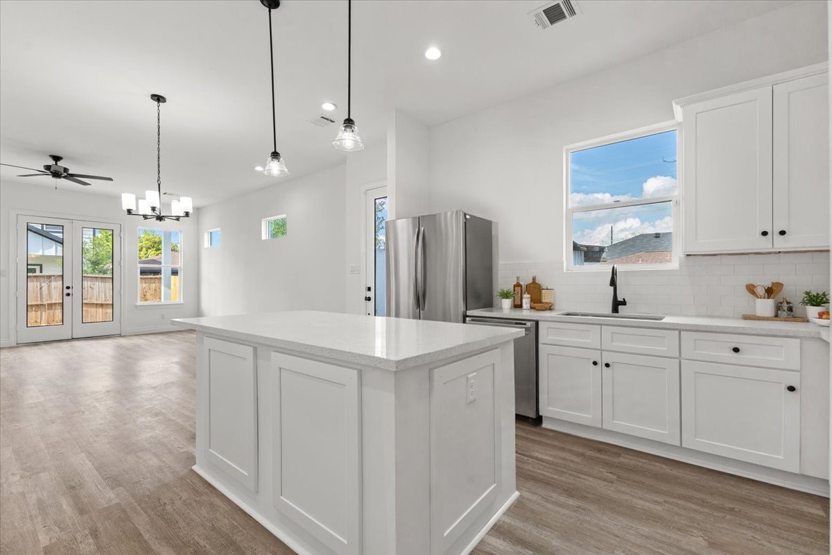 311 Tennessee Street Houston, TX 77029 - Photo 7 of 38 a large kitchen with kitchen island white cabinets and stainless steel appliances