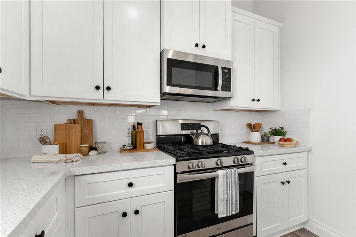 311 Tennessee Street Houston, TX 77029 - Photo 8 of 38 a kitchen with stainless steel appliances granite countertop white cabinets a stove a sink and dishwasher