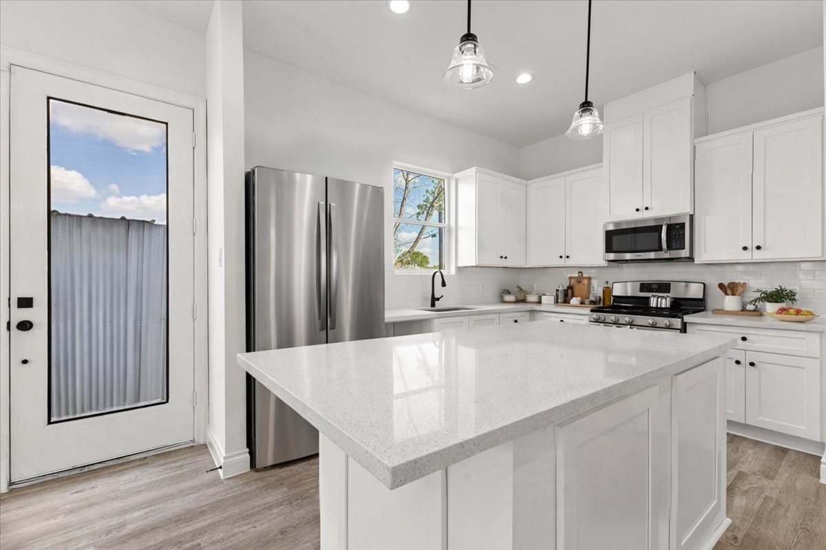 311 Tennessee Street Houston, TX 77029 - Photo 9 of 38 a kitchen with stainless steel appliances a refrigerator a sink a stove a microwave and wooden cabinets