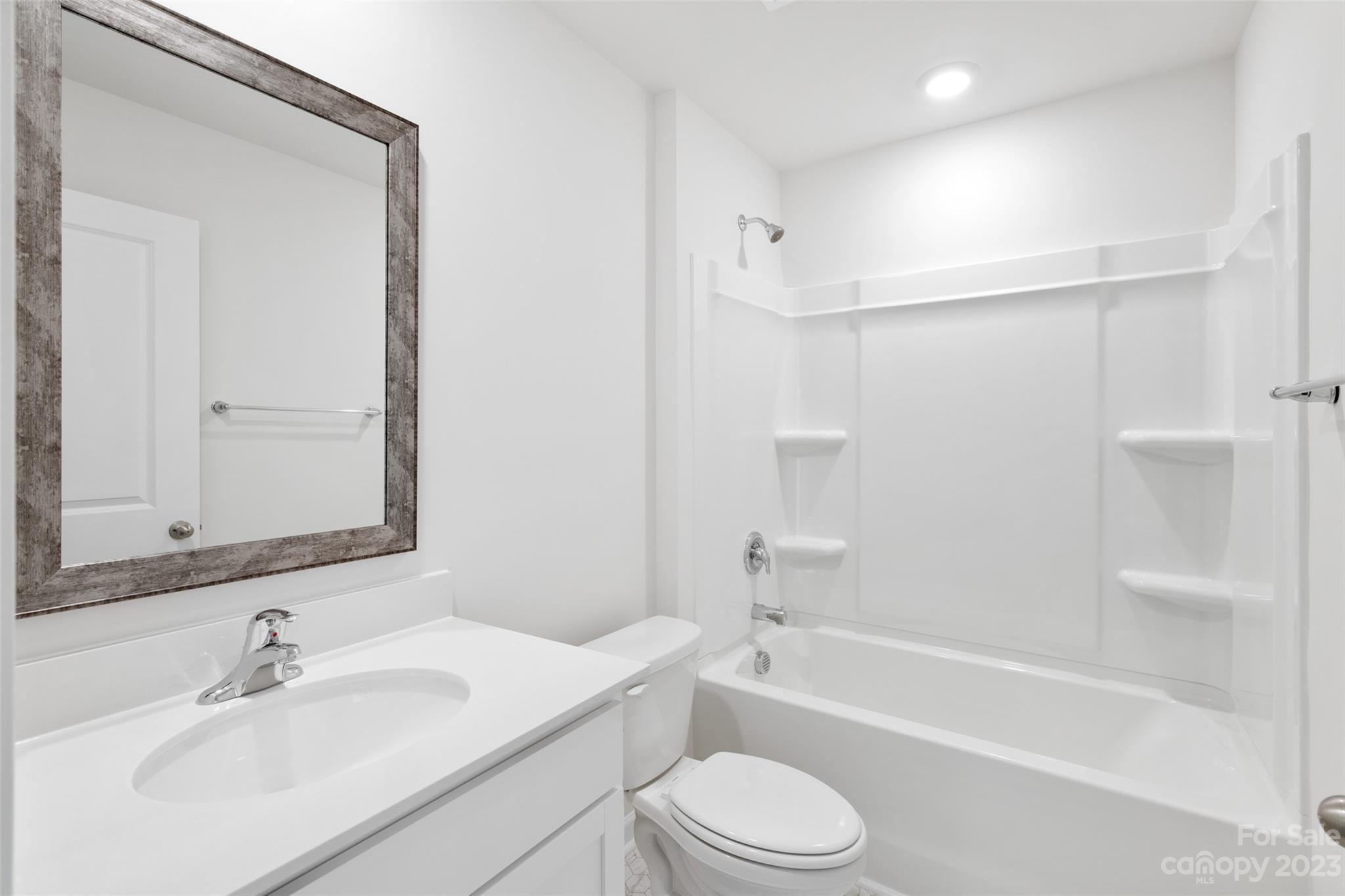 36 Burdock Road Fletcher, NC 28732 - Photo 5 of 18 a bathroom with a bathtub shower sink vanity mirror and toilet