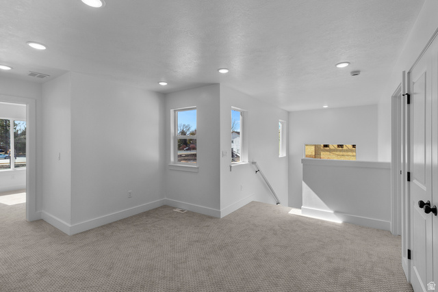 248 West 2920th Street South Logan, UT 84321 - Photo 38 of 47 Loft space featuring recessed lighting, light-colored carpeting, multiple windows, and a half-wall partition