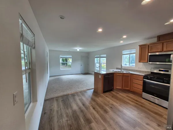 a large kitchen with stainless steel appliances granite countertop a refrigerator and a stove