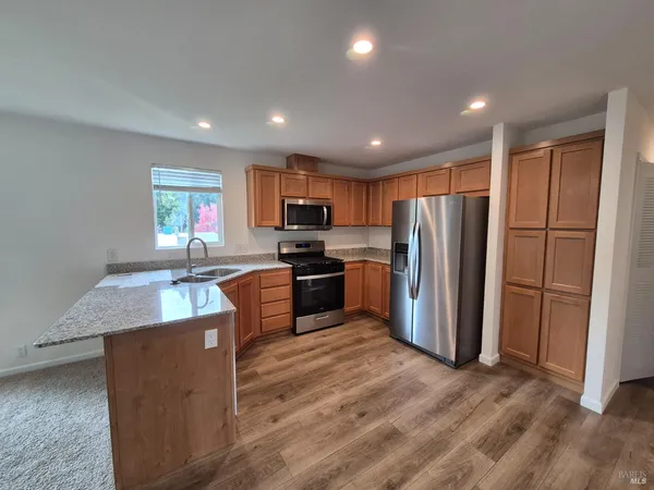 a kitchen with granite countertop stainless steel appliances a refrigerator and a sink