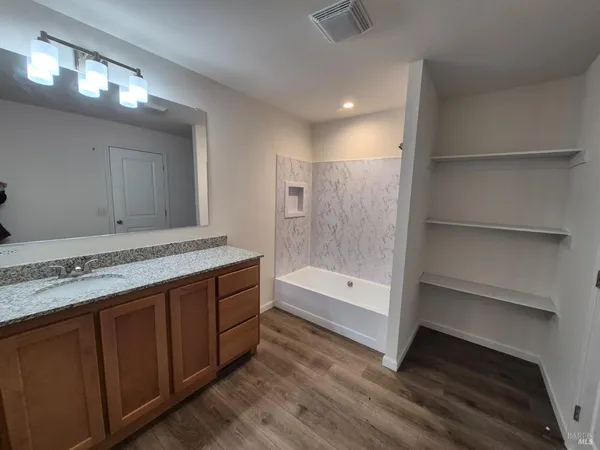 a bathroom with a tub shower and sink