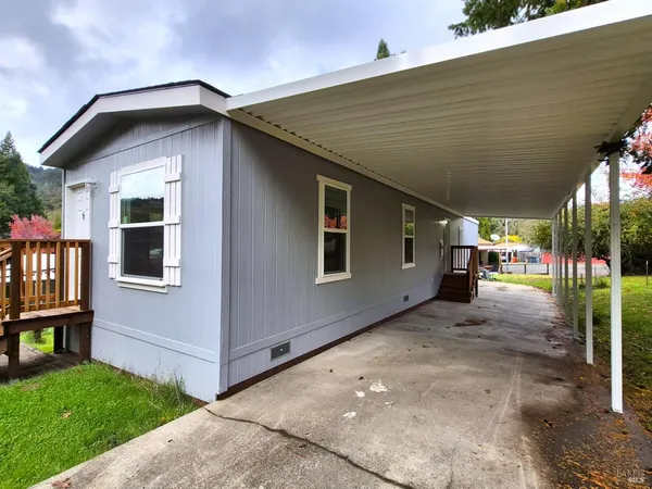 a yellow house with tall trees in front of it