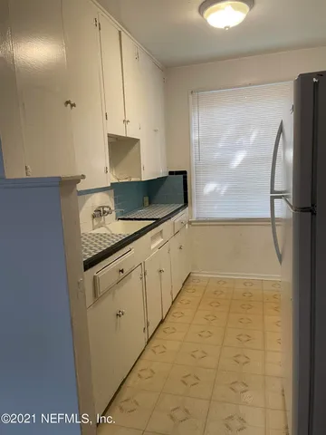 a kitchen with granite countertop white cabinets and stainless steel appliances