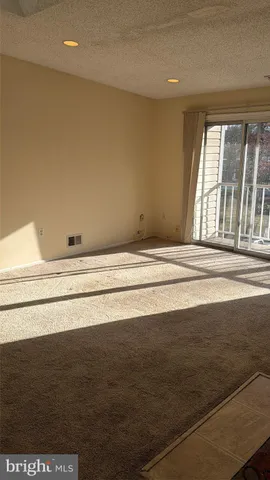a view of a livingroom with an empty space wooden floor and a window