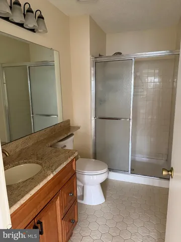 a bathroom with a granite countertop sink toilet and shower