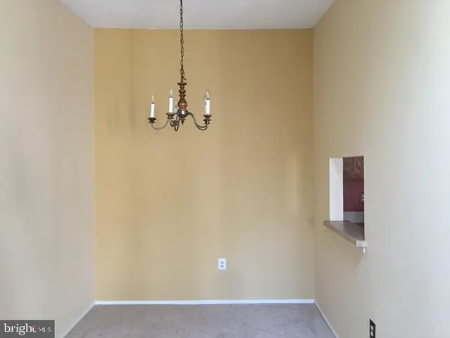 a view of a room with a hanging light and kitchen