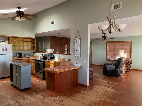 a kitchen with stainless steel appliances kitchen island granite countertop a sink a stove and a refrigerator