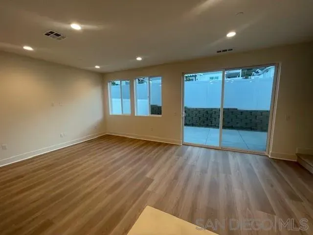 an empty room with wooden floor and sliding door