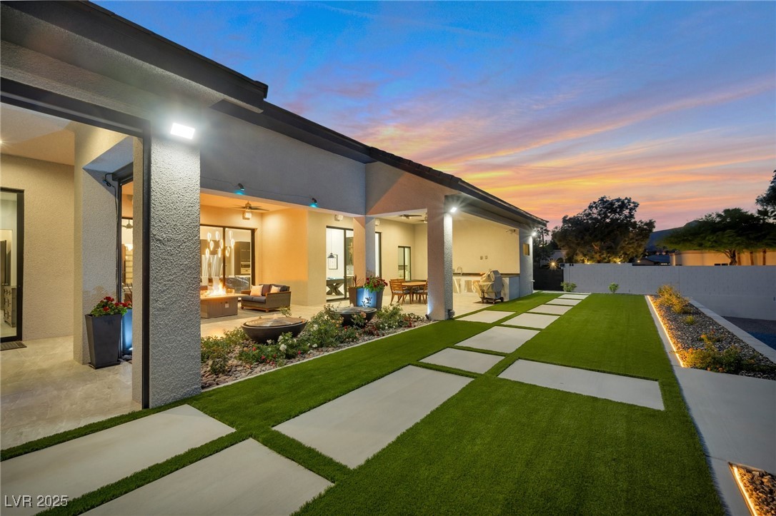 600 Quail Covey Road Henderson, NV 89002 - Photo 10 of 42 Back of property at dusk featuring an outdoor living space with a fire pit