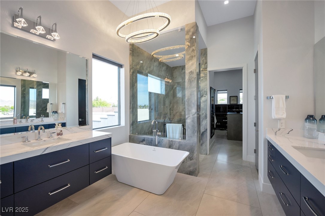 600 Quail Covey Road Henderson, NV 89002 - Photo 16 of 42 Primary bathroom, full bath with walk-in shower, large walk-in closet, two vanities, double sink, and a chandelier