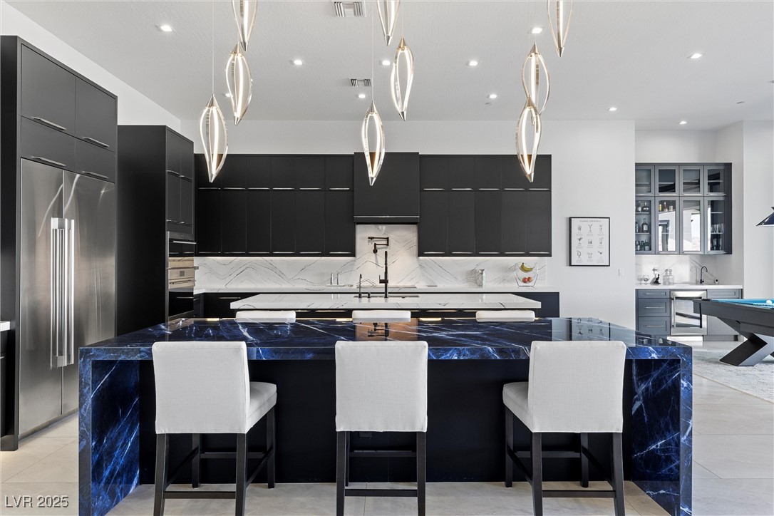 600 Quail Covey Road Henderson, NV 89002 - Photo 24 of 42 Kitchen with stainless steel appliances, dark cabinetry, modern cabinets, and a spacious island
