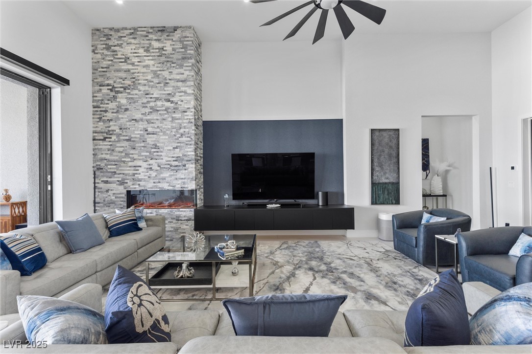 600 Quail Covey Road Henderson, NV 89002 - Photo 28 of 42 Living room with ceiling fan, an electric fireplace (no heat), and a high ceiling fan
