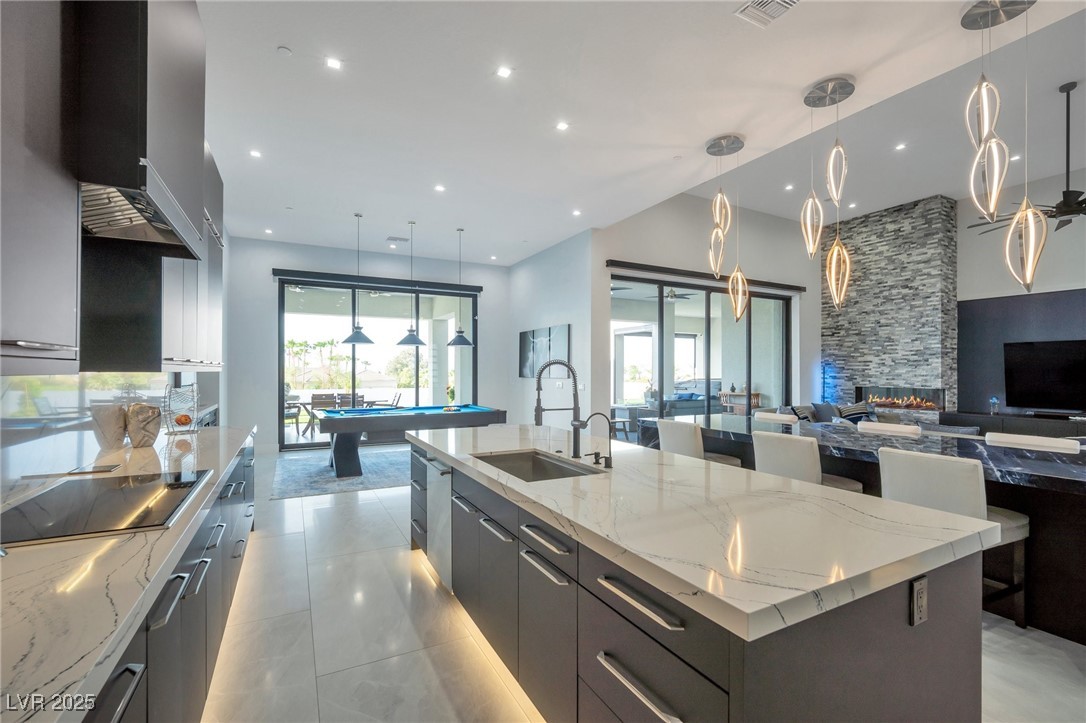 600 Quail Covey Road Henderson, NV 89002 - Photo 42 of 42 Kitchen featuring a sink, a large island, black electric stovetop, wall chimney range hood, and open floor plan