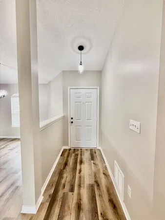 a view of a room with wooden floor and white walls