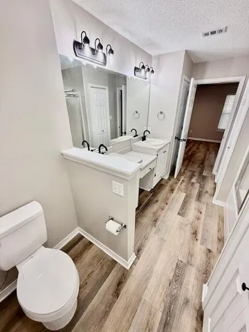 a view of empty room with wooden floor and ceiling fan