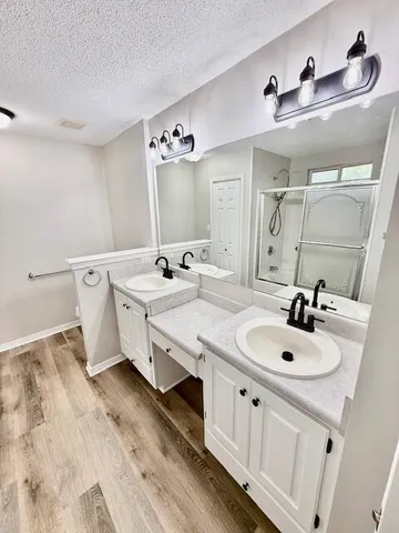 a storage room with a sink and wooden floor