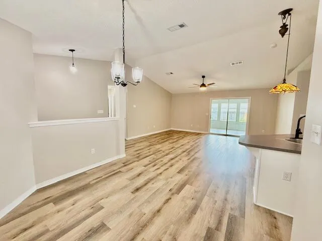 a view of a room with wooden floor and a ceiling fan
