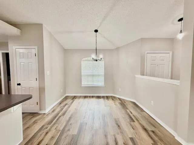 a view of a room with wooden floor and a window