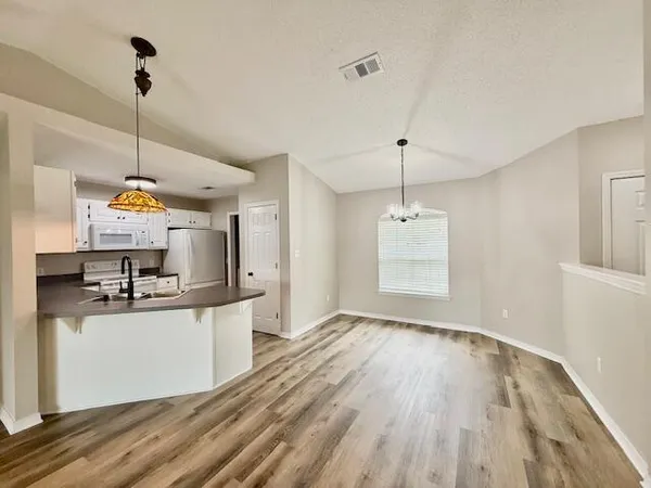 a kitchen with kitchen island a sink and a wooden floor