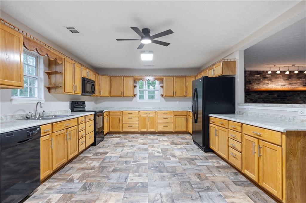 25 Gas Line Road Phenix City, AL 36870 - Photo 9 of 52 Kitchen with black appliances, rail lighting, plenty of natural light, and a ceiling fan