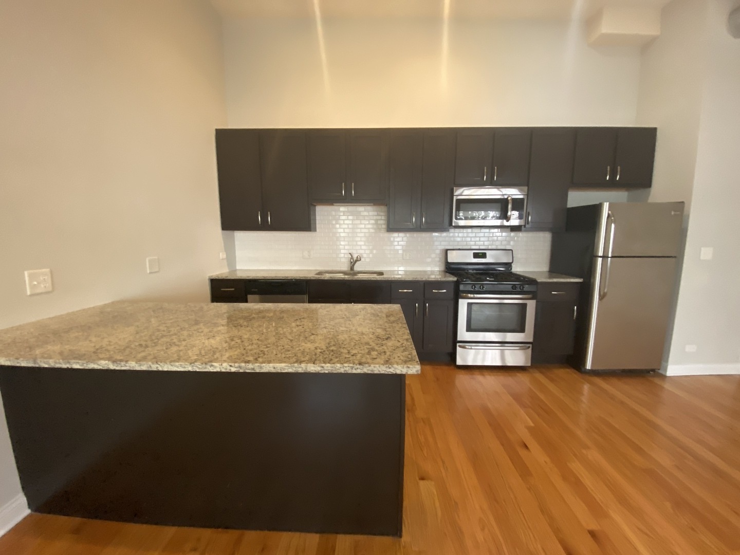 Undisclosed Address Chicago, IL 60613 - Photo 12 of 14 a kitchen with granite countertop a refrigerator a stove and wooden floor