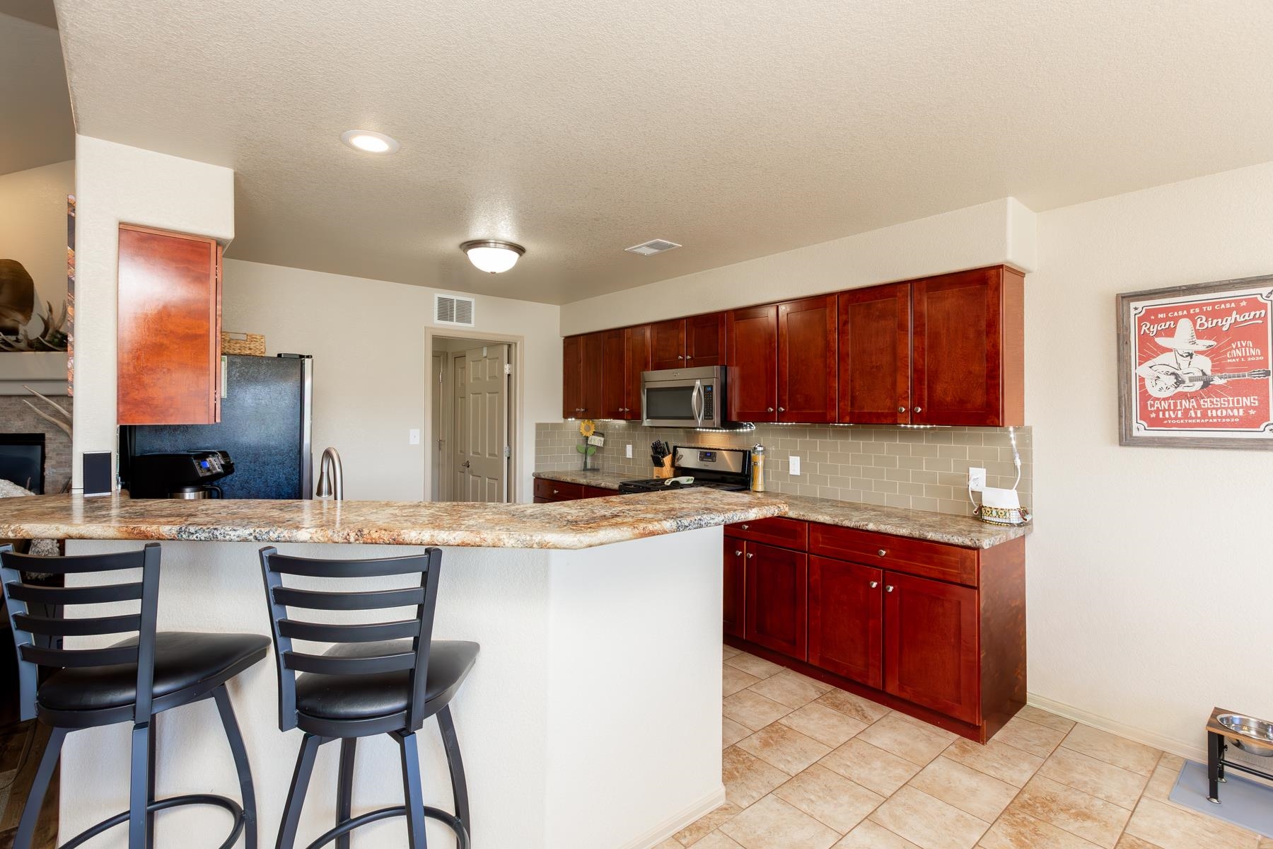 103 Red Rocks Street Fruita, CO 81521 - Photo 23 of 39 a kitchen with stainless steel appliances granite countertop a stove top oven a sink dishwasher and a refrigerator with wooden floor