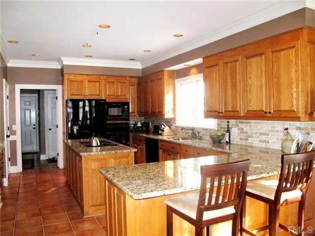 5801 Orchid Valley Road Raleigh, NC 27613 - Photo 7 of 25 Updated gourmet kitchen offers tile floor, brand new granite tops, tiled backsplash, center island w/ gas cooktop, desk area brand new Bosch dishwasher, wine fridge and tons of cabinet space. Kitchen