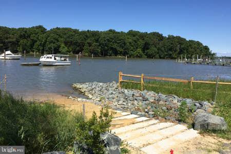 2605 Harrington Road Chester, MD 21619 - Photo 27 of 29 a view of a lake with beach and wooden fence